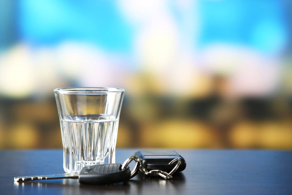 Glass of alcoholic drink and car key